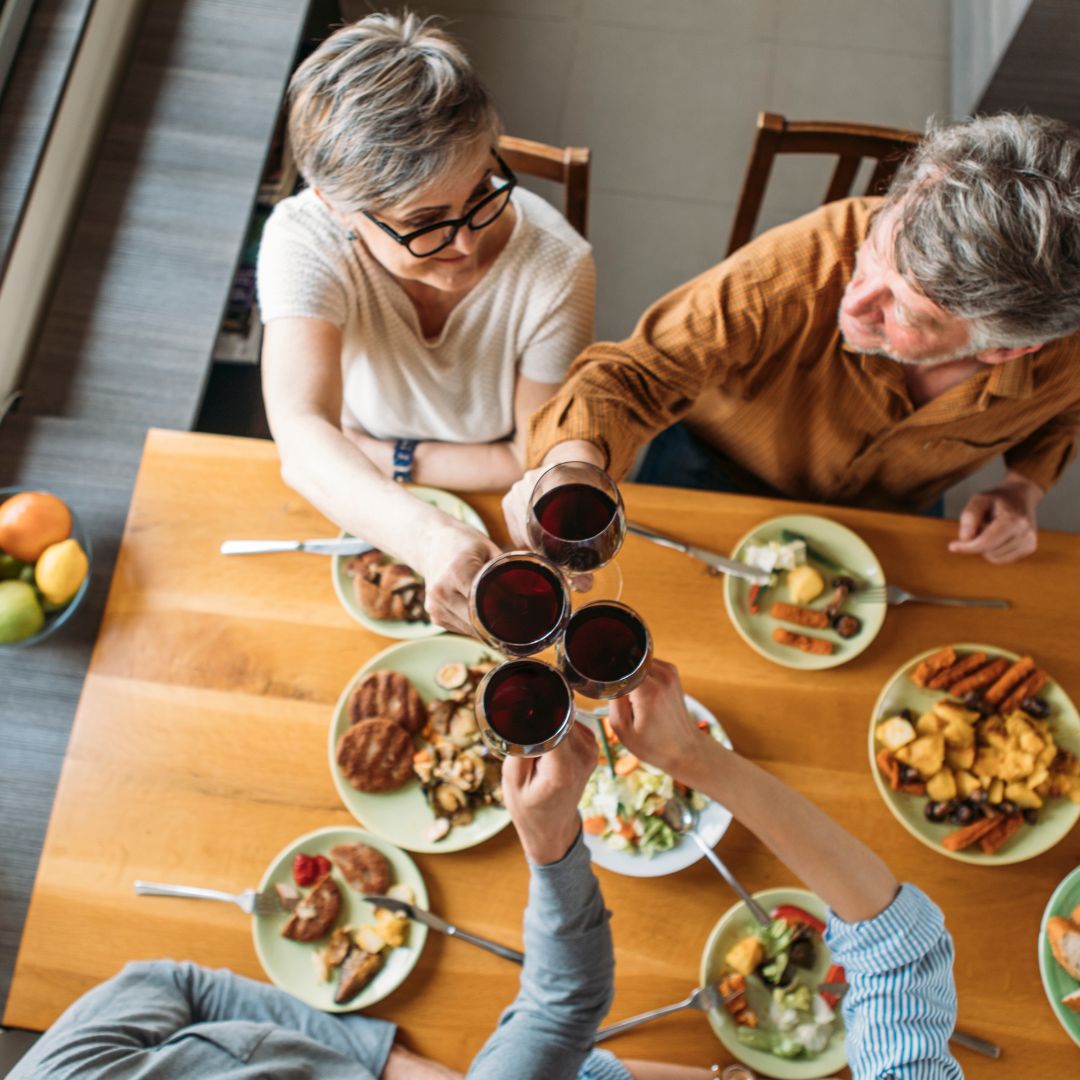 Family eating at a table and enjoying a meal together.